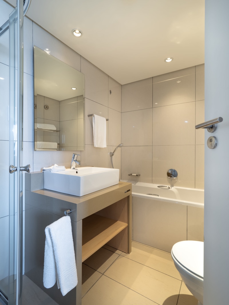 flooring, illuminated, domestic room, bathroom, tiles, house, hotel, shower, faucet, empty, contemporary, hygiene, architecture, ceiling, bath, tile, hotel bathroom