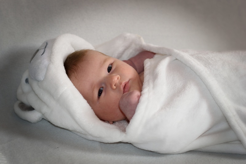 looking at camera, childhood, lying down, relaxation, wrapped in a blanket, innocence, young, portrait, babyhood, mouth open, baby girl, 5K, headshot