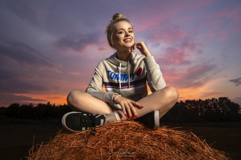 field, gray, women outdoors, looking away, cloud - sky, nature, front view, outdoors, hay, s, looking at viewer, real people, smiling, legs crossed, women