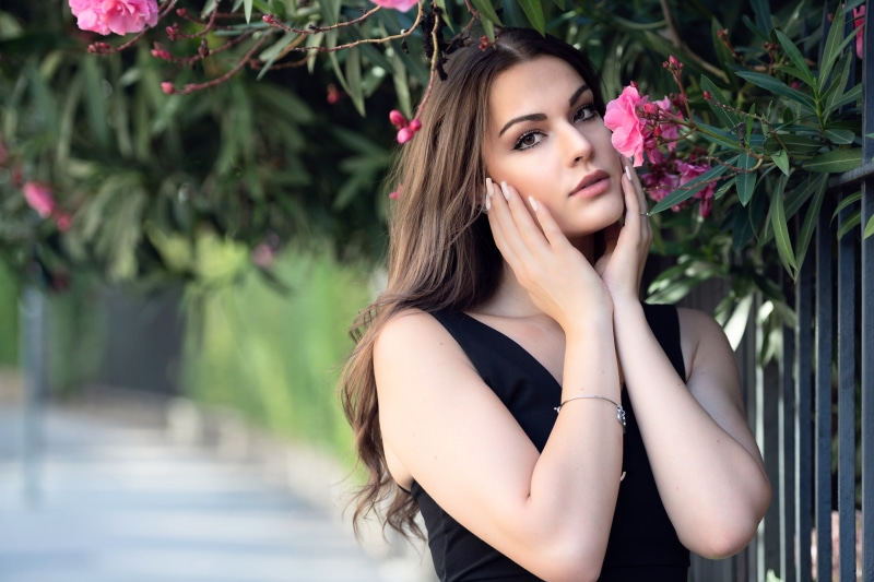 brunette, women outdoors, women, Luigi Malanetto, flowers, 2K, hand on face, black tops, looking at viewer