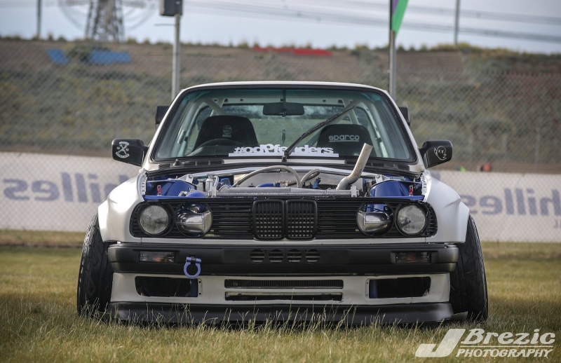 mode of transportation, focus on foreground, land vehicle, number, BMW E30, car, day, motor vehicle, transportation, grass, Stance, field, plant, land