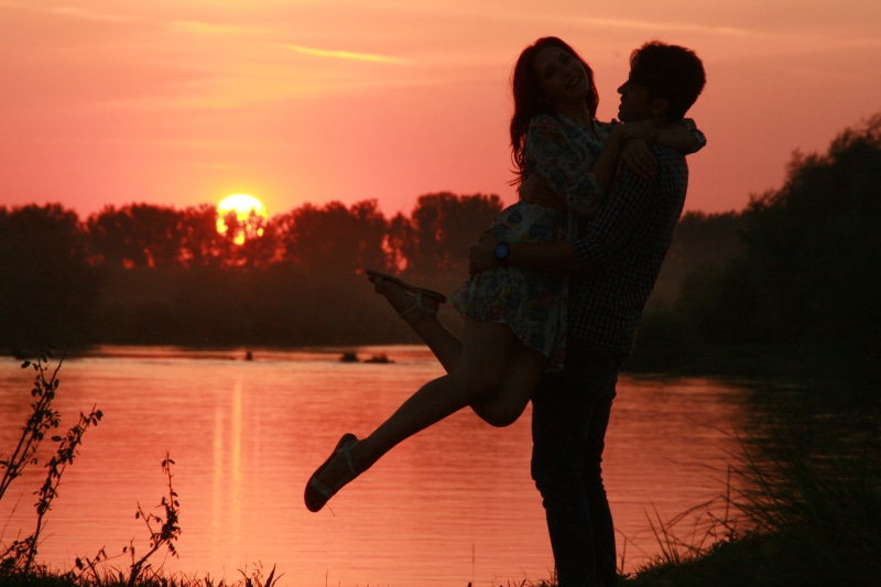real people, leisure activity, man, carrying, front, human arm, adult, people, outdoors, sun, water, cheerful, females, two People, full length, sunset