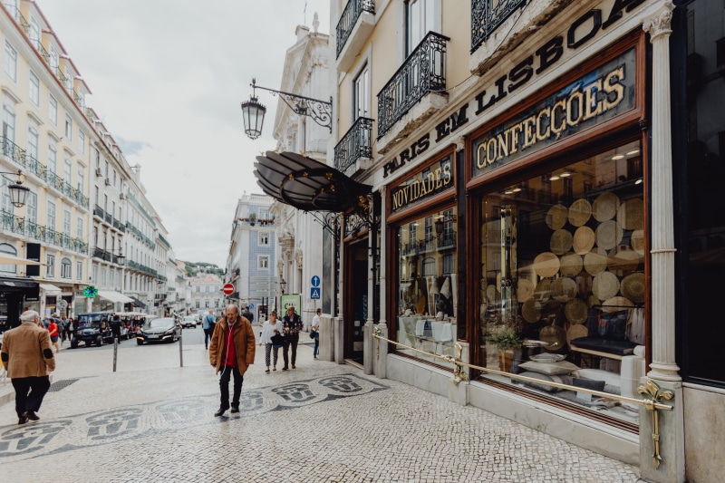 building exterior, architecture, Europe, portugal, outdoors, men, built structure, walking, text, real people, lisboa, lifestyles, people, day, city, group of people