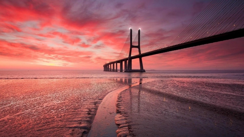 built structure, vasco da gama bridge, shore, water, horizon over water, sky, low tide, europe, bridge - man made structure, pink sky, calm, beach, sea