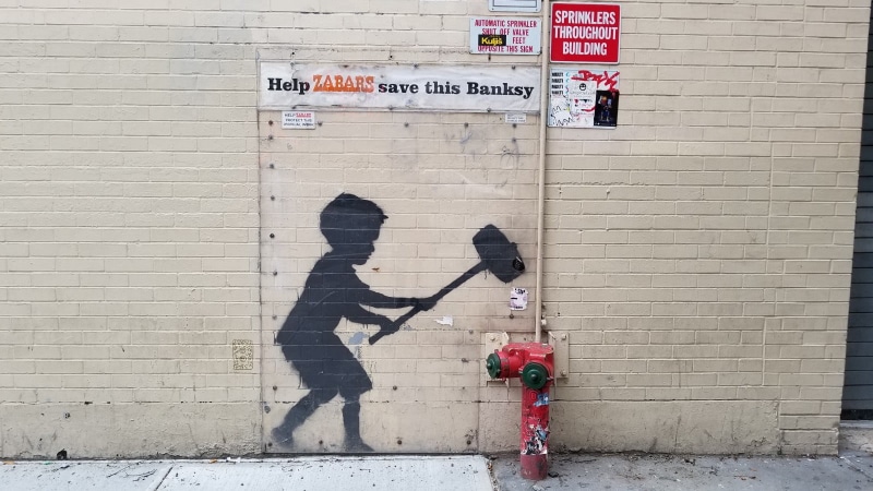 text, outdoors, urban, wall - building feature, non-western script, nature, no people, Banksy, sign, wall, concrete, building exterior, red, built structure