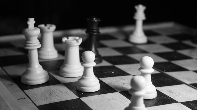 monochrome, board game, black background, queen - chess piece, focus on foreground, pawn - chess piece, still life, indoors, challenge, chess piece, game