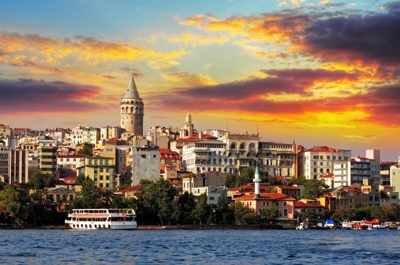 color Image, buildings, harbor, skyscraper, ferry, urban Scene, office building exterior, orange color, scenics, sea, cultures, sunset, twilight, building