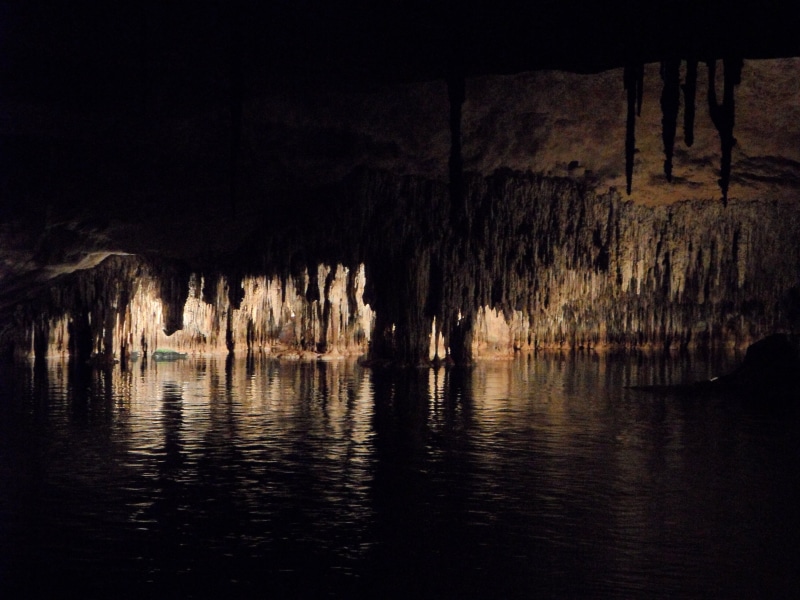 tranquil scene, stalagmite, mysterious, grotto, illuminated, outdoors, nature, rock formation, water, inside, rock, mirroring, dark, speleothems, stalagmites