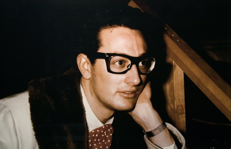 contemplation, buddy holly, looking At Camera, headshot, menswear, black background, studio Shot, adult, glasses, shirt, indoors, caucasian Ethnicity, one Person