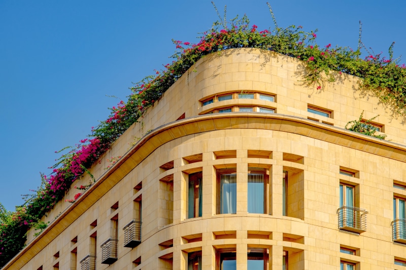 office building exterior, apartment, clear sky, building exterior, beirut, residential district, blue, facade, nature, sunlight, pink color, day, greenery