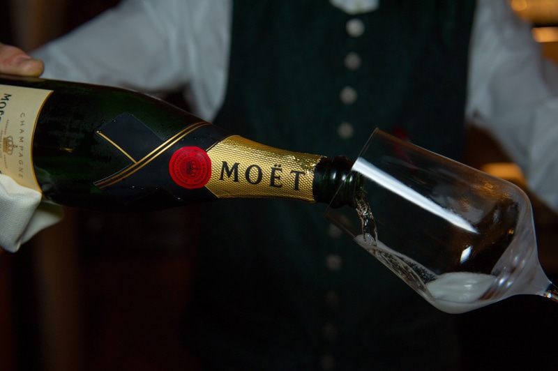 benefit from, wine bottle, famous, red wine, bartender, one person, waiter, moet, human hand, luxury, midsection, focus on foreground, human body part