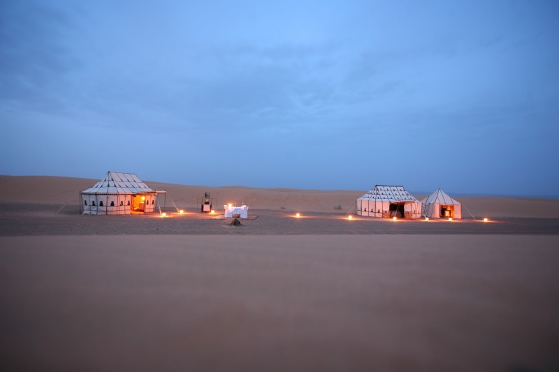 building exterior, sand, night, sky, white, blue, lighting equipment, environment, residential district, tent, outdoors, building, dusk, desert, built structure