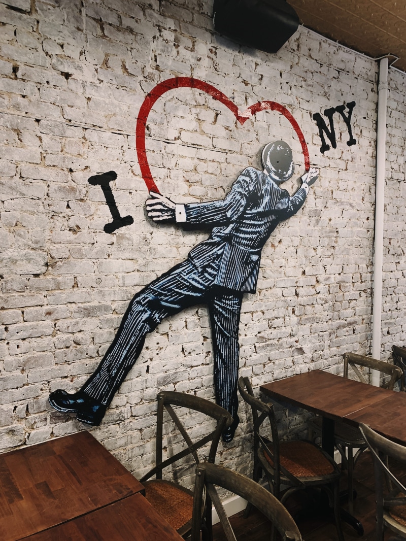 text, new york, wood - material, painting, pizza, table, seat, furniture, human representation, drawing, chair, ny, art, no people, 4K, person, brick wall