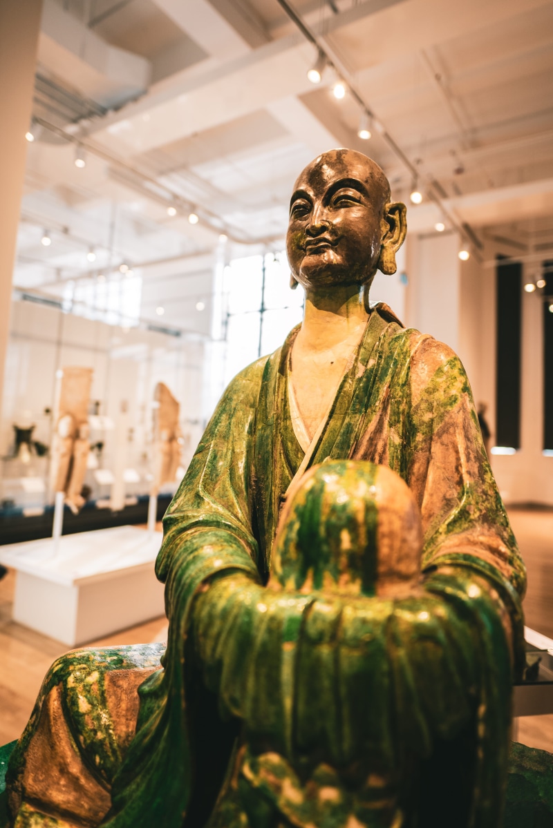 sculpture, casual clothing, three quarter length, 5K, males, waist up, figurine, men, wood, apparel, real people, buddha, front view, art, furniture, person