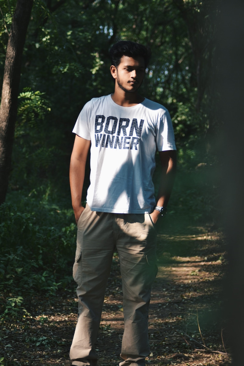 tree, outdoors, shirt, sunlight, cargo, handsome, 4K, brown, wear, teenage boys, full length, lifestyles, nature, young adult, pants, young men, facial hair