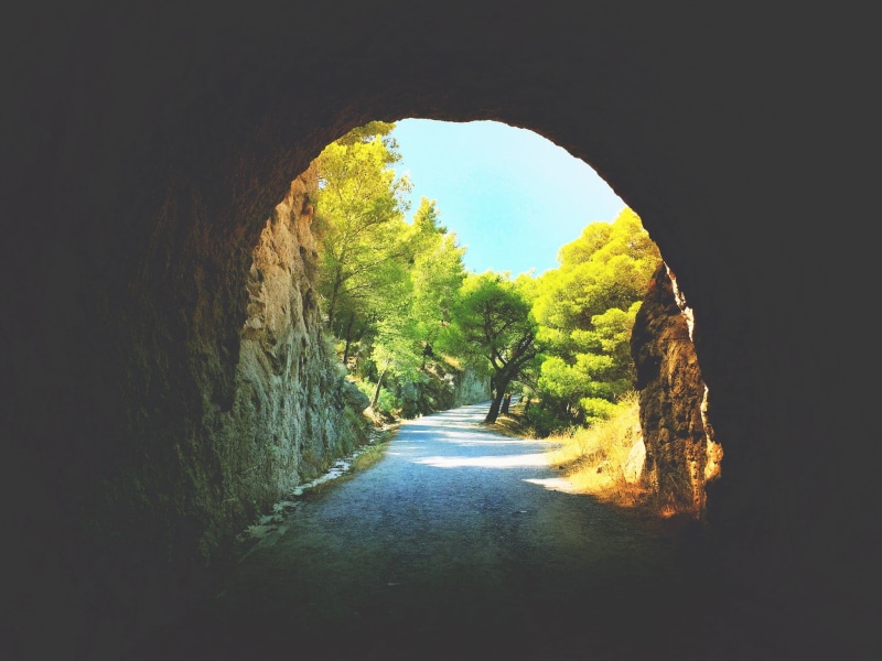 day, dirt road, growth, tree, outdoors, wall, beauty in nature, arch, gravel, nature, no people, natural arch, direction, tunnel, transportation, arched