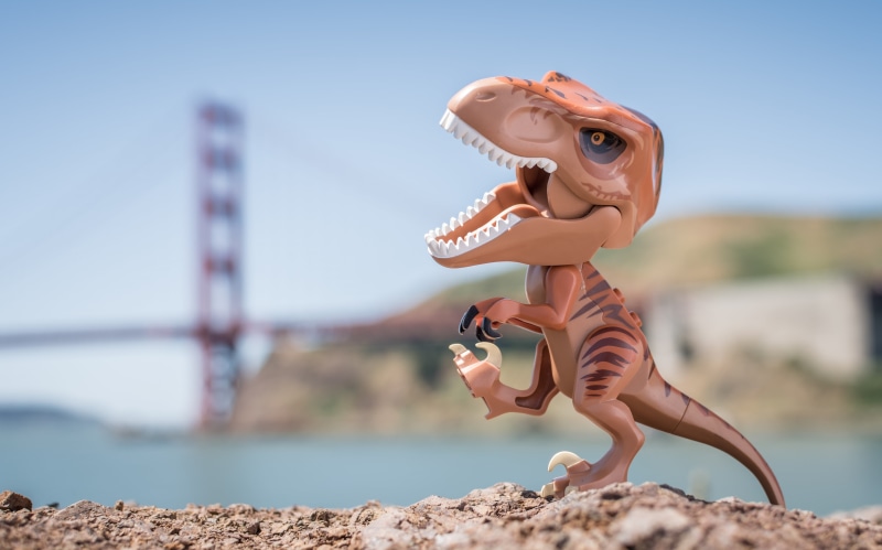 solid, focus on foreground, sky, t-rex, 5K, day, sea, human representation, dinosaur, water, leisure activity, lifestyles, sunlight, one person, rock - object