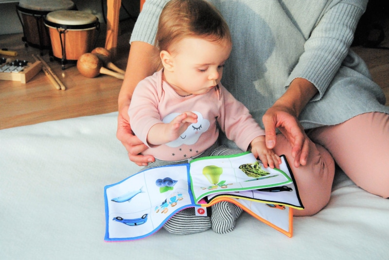child, indoors, holding, the little girl, baby, men, flooring, educational, parent, read to the child, females, childhood, sweatshirt, wearing, innocence