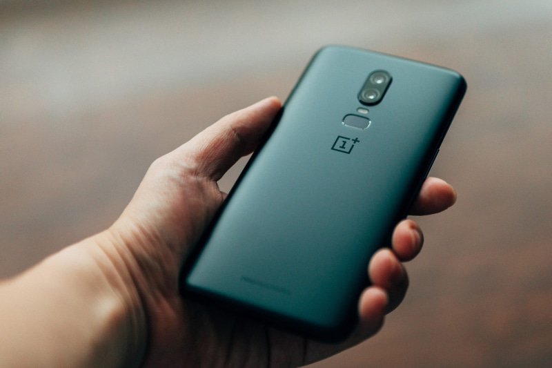 smart phone, caucasian, fingerprint sensor, mobile, single object, adult, text, finger, holding, person, gadget, black, blur, hold, people, oneplu, dual camera