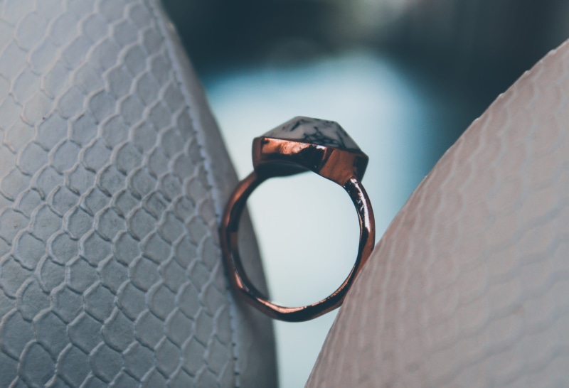 day, car seat, shape, plant, focus on foreground, single object, gemstone, hardware, human hand, diamond, close-up, personal accessory, accessories, outdoors