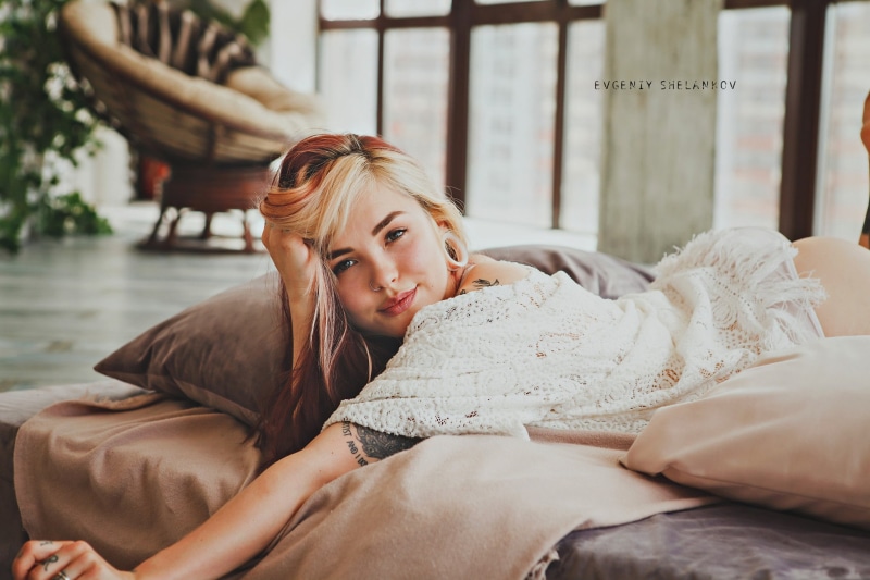 resting, young adult, furniture, white, tattoo, young women, sitting, one person, lifestyles, woman, hairstyle, warm clothing, piece, real people, lying