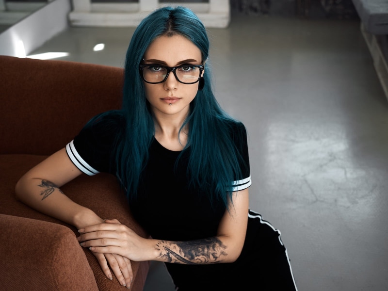 bokeh, hair, inked girls, front view, indoors, glasses, tattoo, portrait, women with glasses, hairstyle, dress, long hair, looking at viewer, lifestyles