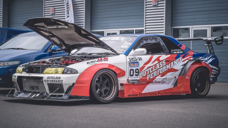 retail, helm, land vehicle, motorsport, wheels, day, architecture, drift, force, vehicle, cooling, city, race, built structure, street, race car driver