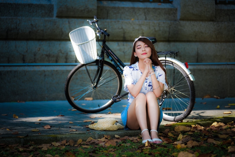 1080P, beautiful woman, model, outdoors, clothing, adult, leaves, looking at camera, lifestyles, beauty, brunette, transportation, hairstyle, wheel, sandals