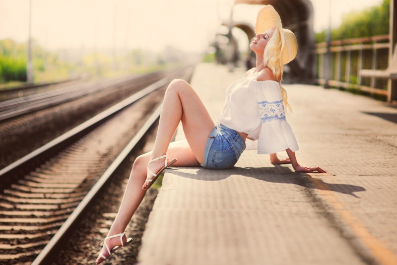 sandals, adult, women outdoors, hat, mode of transportation, 2K, women, nature, depth of field, jean shorts, casual clothing, track, young adult, sitting