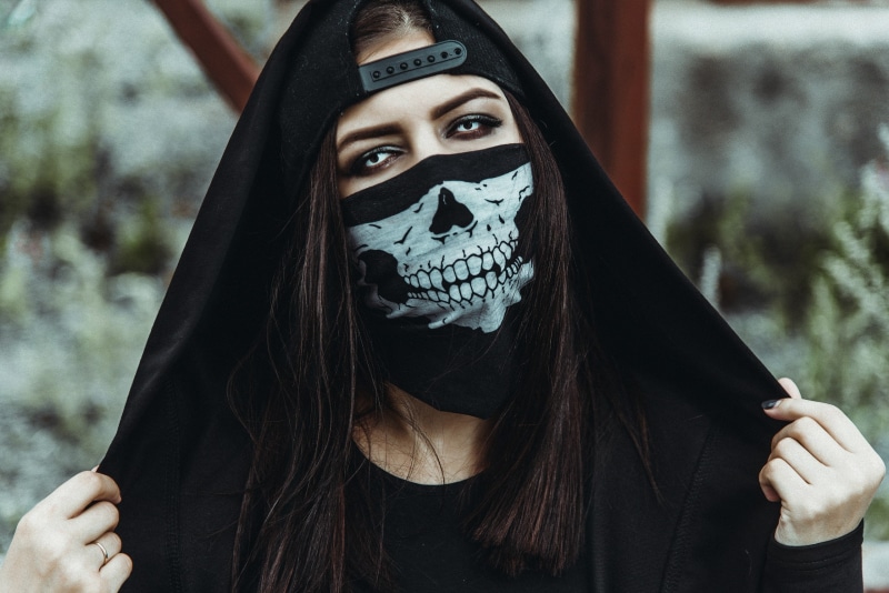 2K, hoods, hairstyle, spooky, focus on foreground, real people, women, black clothing, one person, baseball caps, women outdoors, headshot, skeleton, leisure activity