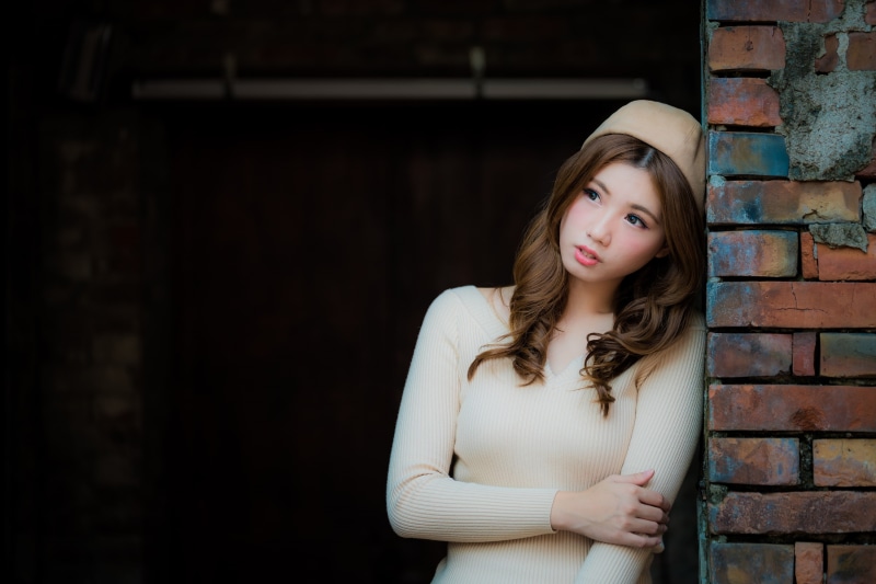women outdoors, one person, front view, model, standing, arms crossed, Asian, hairstyle, waist up, brick wall, young adult, women, looking into the distance