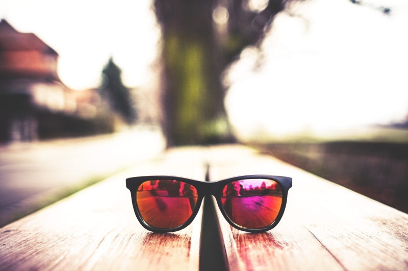 accessories, close-up, security, sunglasses, table, bench, purple, reflection, personal perspective, outdoors, wood, focus on foreground, people, personal accessory
