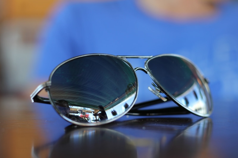 selective focus, reflection, close-up, indoors, sunglasses, black, security, table, elegance, aviator, eyewear, eyeglasses, accessory, glass - material
