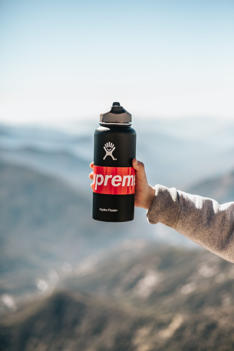 focus on foreground, person, hand, lifestyles, daytime, supreme, hydroflask, sky, day, 5K, bottle, flask, nature, leisure activity, western script, sea