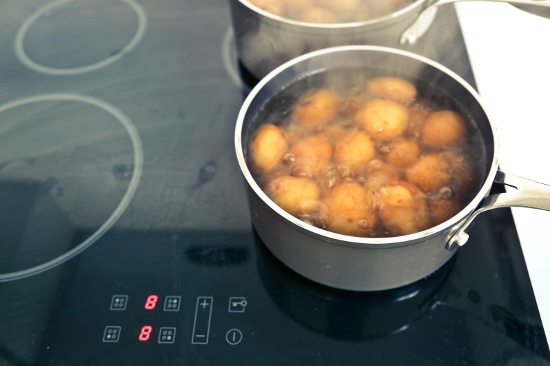 cooktop, kitchen utensil, no people, black, indoors, cooking pan, cuisine, equipment, preparation, high angle view, soup stock, zone, heat - temperature