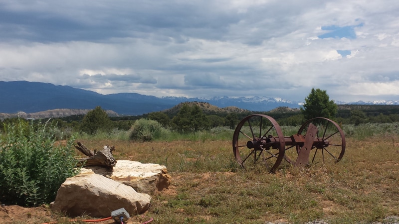old west, history, wagon wheel, tranquil scene, environment, sky, western remnant, 2K, western implements, field, plant, beauty in nature, mountain, nature