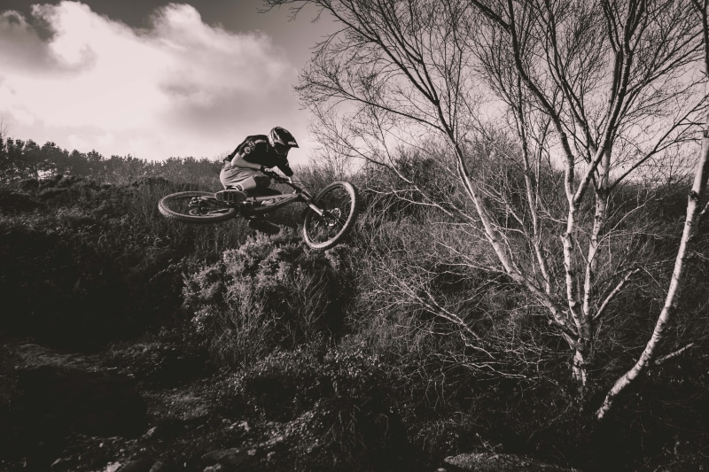headwear, biker, bare tree, land vehicle, bicycle, adventure, outdoors, extreme sports, sport, lifestyles, one person, mode of transportation, Mountain bike