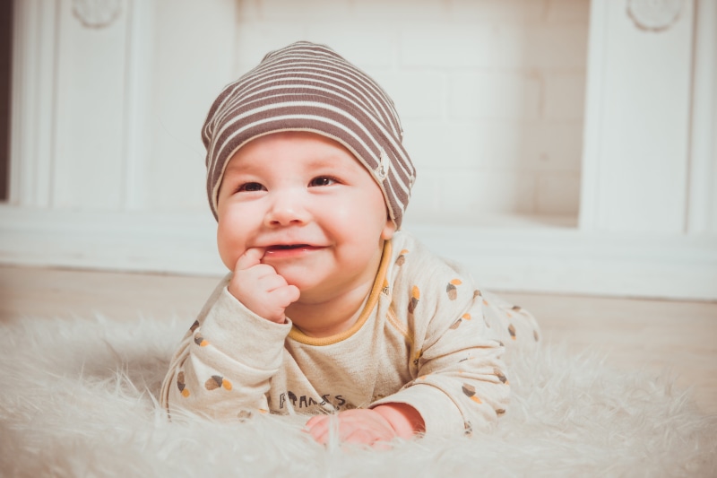 enjoyment, right, home interior, index, biting, kid, cute, front view, childhood, baby, hat, portrait, one person, smiling, innocence, adorable, clothing