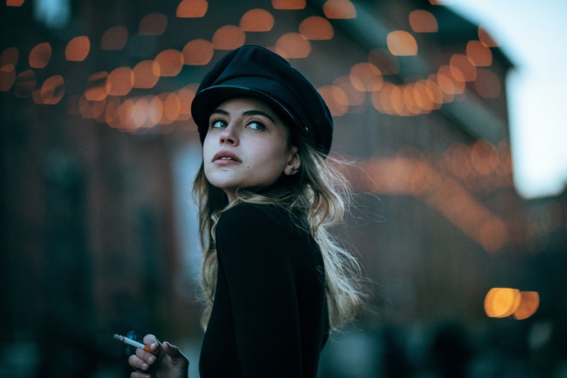 one person, real people, contemplation, hat, leisure activity, cigarettes, model, women, black clothing, scars, headshot, lifestyles, focus on foreground