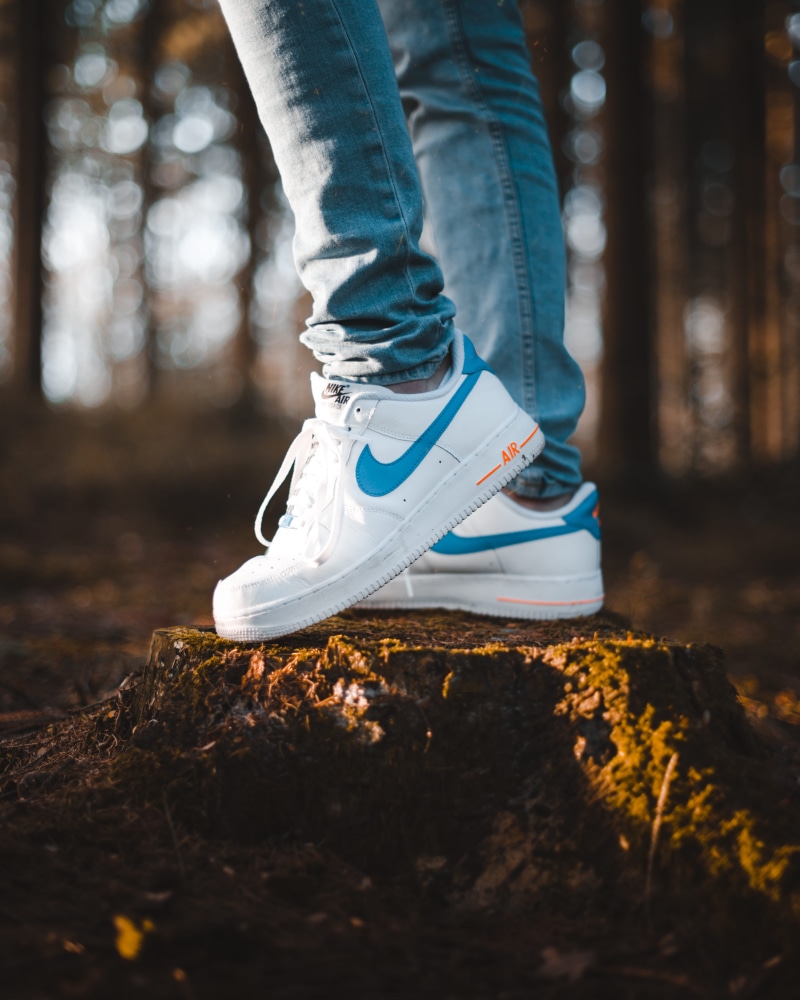 jeans, standing, orange, footwear, human, human leg, sneaker, urban, day, tree, forest, nike, outdoors, land, fashion, fall, pants, air, real people, casual clothing