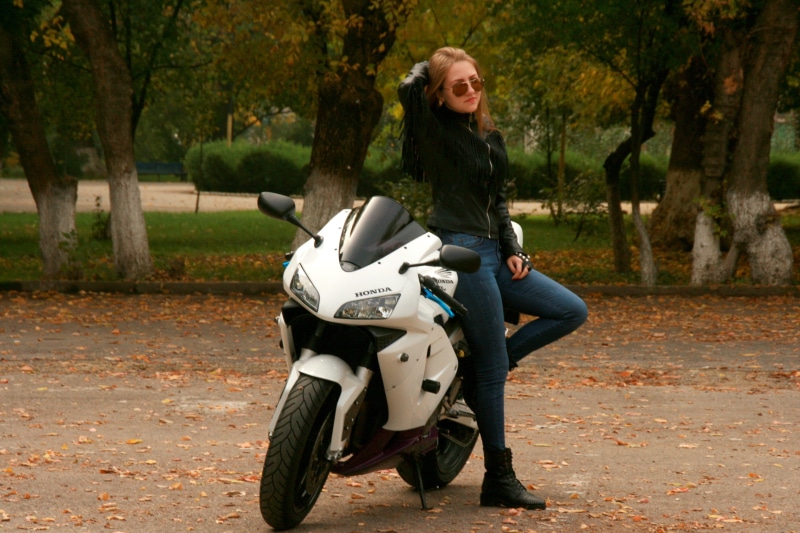 park, riding, sportsbike, black, sitting, tree, outdoors, one person, looking at camera, ride, leisure activity, smiling, beauty, women, honda, standing