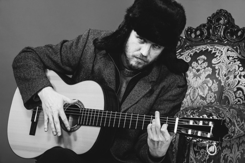 front view, middle finger, leisure activity, skill, man, coat, acoustic guitar, men, young men, arts culture and entertainment, mature men, classical guitar