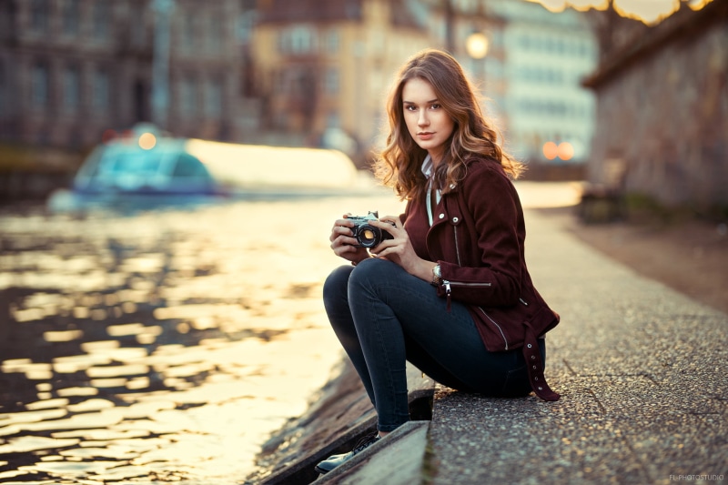 blonde, outdoors, city, long hair, lifestyles, red jackets, beauty, women, wireless technology, young women, camera, sitting, full length, hair, Claire Godard