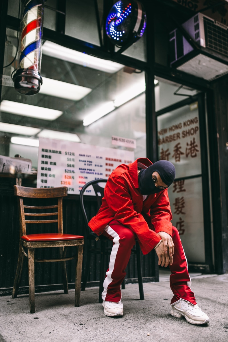 day, chinatown, building exterior, full length, lifestyles, man, seat, white, winter, sitting, pants, mask, wearing, leisure activity, 4K, jacket, balaclava