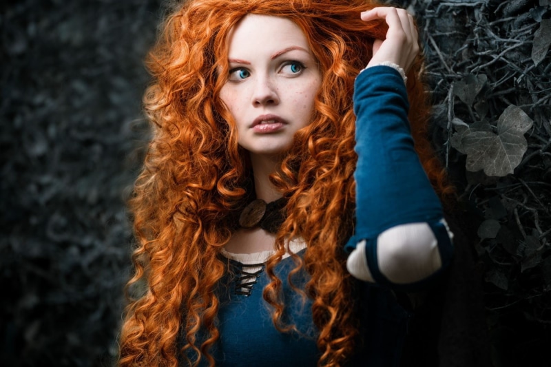 portrait, top, young adult, looking at camera, hair, hairstyle, human hair, blue, contemplation, clothing, dyed red hair, Brave, black background, selective coloring