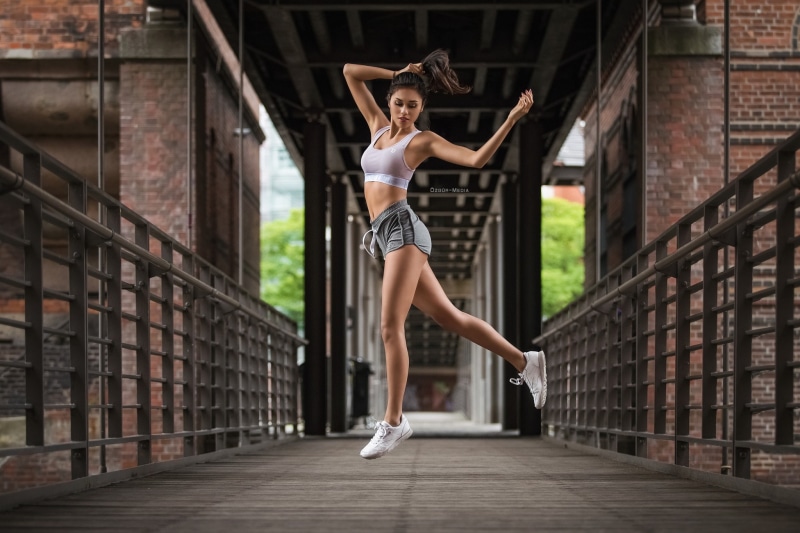 belly, real people, hairstyle, jumping, young adult, lifestyles, sneakers, day, leisure activity, full length, beautiful woman, ponytail, one person, brunette