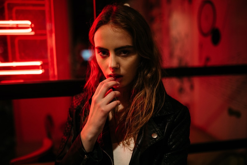 beauty, indoors, young adult, portrait, finger on lips, women outdoors, front view, brunette, model, headshot, focus on foreground, red light, hair, leather jackets
