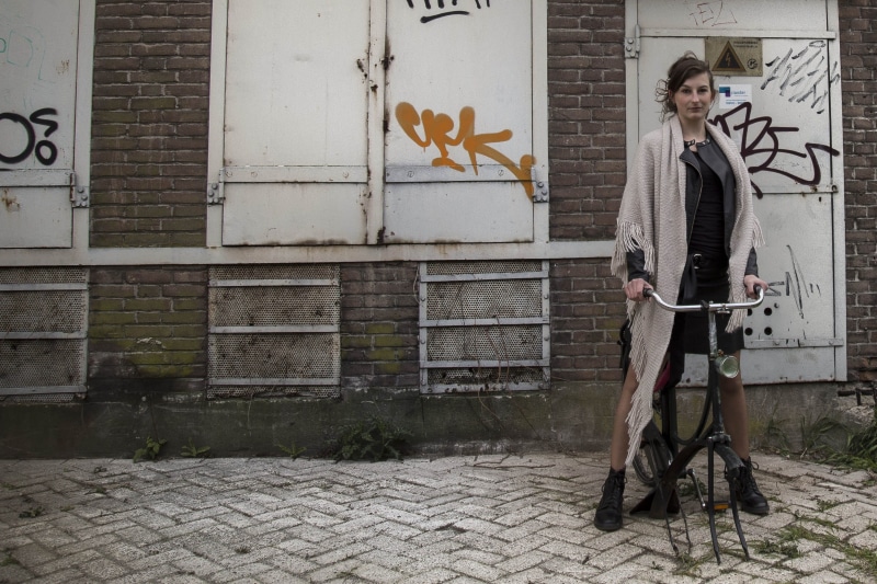 Woman, watch, brick, brown eyes, work of art, real people, bicycle, leisure activity, males, man, young women, red, street, artistic, adult, architecture