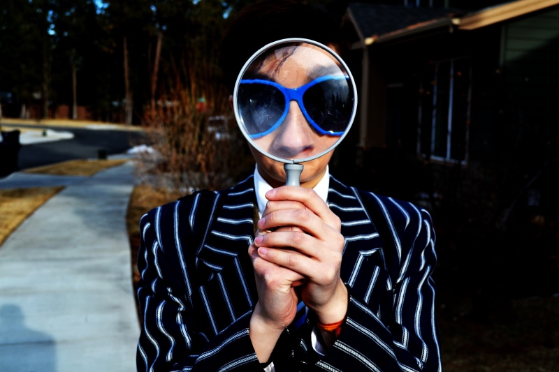 real people, adult, young adult, sunglasses, lifestyles, focus on foreground, outdoors, one man only, using, casual clothing, wooden, magnifying glass