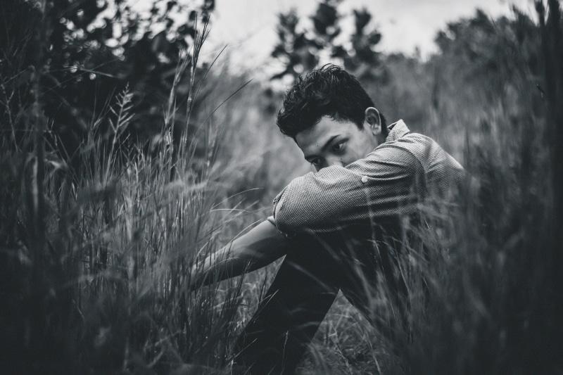 sitting, contemplation, lonely, focus, real people, lifestyles, looking away, land, sad, casual clothing, monochrome, depression, side view, blur, leisure activity